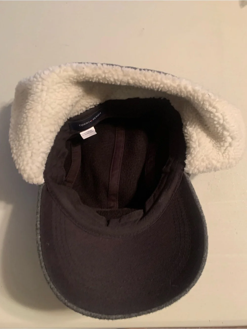 Tommy Hilfiger fleece winter cap featuring fold-down ear flaps with white sherpa